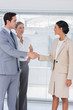 Business people shaking hands in bright office