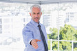 Happy businessman extending arm for handshake