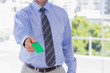 Businessman offering green business card