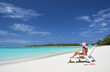 Girl with a glass of orange on the beach of Exuma, Bahamas