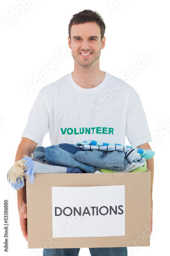 Photo: Attractive man holding donation box with clothes Attractive man holding donation box with clothes