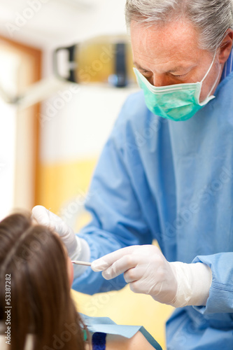 Photo: Dentist doing a treatment Dentist doing a treatment