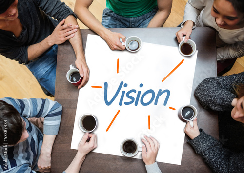 Photo: Team brainstorming over a poster with vision written on it Team brainstorming over a poster with vision written on it
