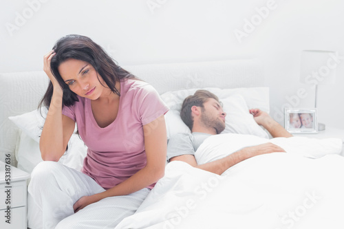 Photo: Anxious woman thinking while she is sat in her bed Anxious woman thinking while she is sat in her bed