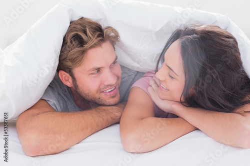 Photo: Couple under quilt smiling Couple under quilt smiling