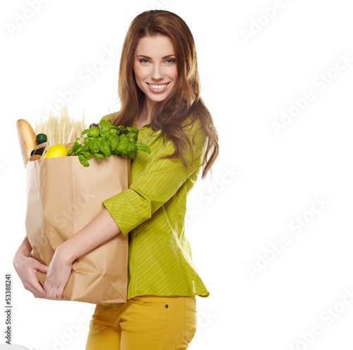 Photo: Young woman holding a grocery bag full of bread Young woman holding a grocery bag full of bread