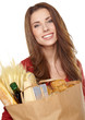 Young woman holding a grocery bag full of bread