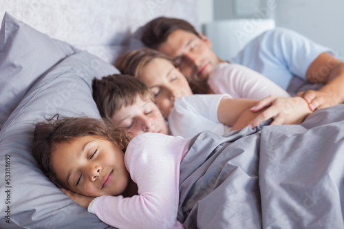 Photo: Cute family sleeping in bed Cute family sleeping in bed