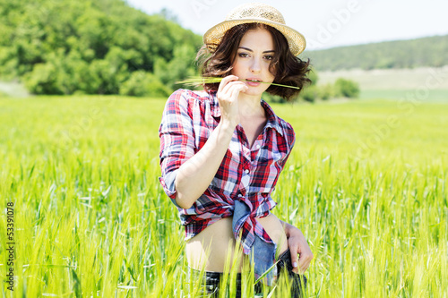 Photo: Beautiful woman in hat on summer meadow Beautiful woman in hat on summer meadow