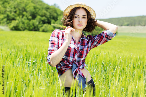 Photo: Beautiful woman in hat on summer meadow Beautiful woman in hat on summer meadow