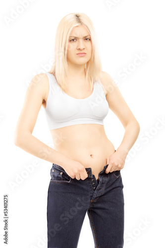 Photo: Woman trying to put on old pair of jeans Woman trying to put on old pair of jeans