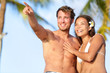 Photo: Couple on beach happy in swimwear, man pointing Couple on beach happy in swimwear, man pointing