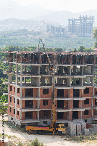 Photo: Truck crane lifted bricks at top floor for construction building Truck crane lifted bricks at top floor for construction building