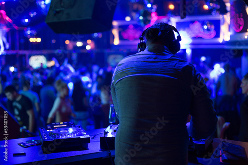 Photo: DJ turns the records at the club under the blue light DJ turns the records at the club under the blue light