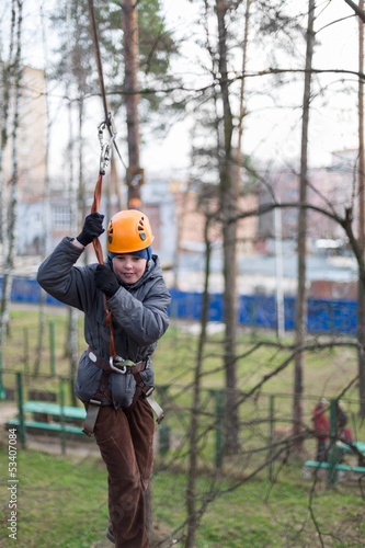 Photo: Little climber passes the obstacle with safety rope Little climber passes the obstacle with safety rope