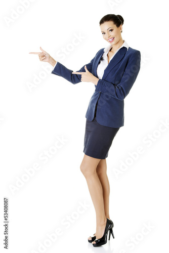 Photo: Happy young business woman pointing on copy space Happy young business woman pointing on copy space