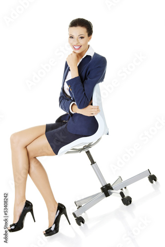 Photo: Beautiful successful businesswoman sitting on ofice chair Beautiful successful businesswoman sitting on ofice chair