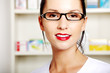 Photo: Young pharmacist in uniform standing in drugstore Young pharmacist in uniform standing in drugstore