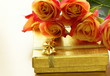 orange roses and box with gifts on gold background