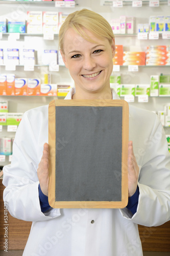 Photo: Freundliche Apothekerin hält leere Tafel Freundliche Apothekerin hält leere Tafel