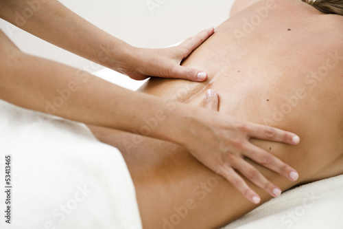 Photo: Young woman getting back massage Young woman getting back massage