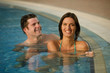 Young couple relaxing in swimming pool at health club