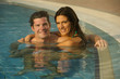 Young couple relaxing in swimming pool at health club