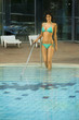 Young woman stepping into swimming pool