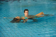 Young couple relaxing in swimming pool at health club