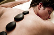 Young man doing hot stone therapy