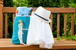 Blue bag with towel and hat for outdoor pool or beach weekend.