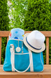 Blue bag with towel and hat for outdoor pool or beach weekend.