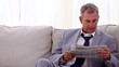 Smiling businessman reading newspapers