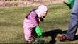 Little girl (year and 5 months old) watering plants in the yard