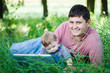 father with his son on nature with laptop
