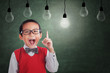 Asian boy has idea under light bulb in class