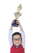 Photo: Boy holding trophy above his head - isolated Boy holding trophy above his head - isolated