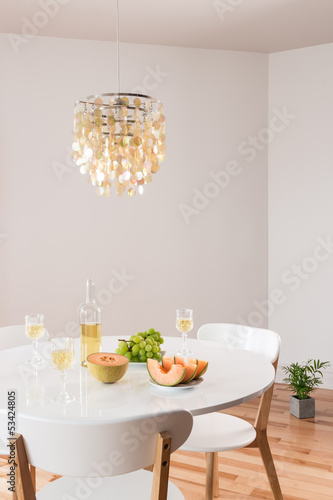 Photo: Decorative chandelier and elegant table with white wine Decorative chandelier and elegant table with white wine