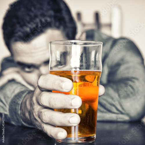 Photo: Grunge image of a drunk man holding a glass of beer Grunge image of a drunk man holding a glass of beer