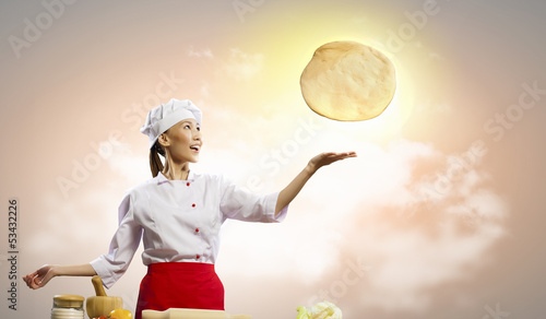 Photo: Asian female cook making pizza Asian female cook making pizza