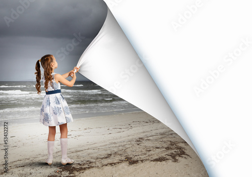Photo: Little girl turning page Little girl turning page