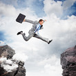 Businessman jumping over gap
