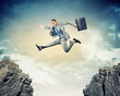 Businessman jumping over gap