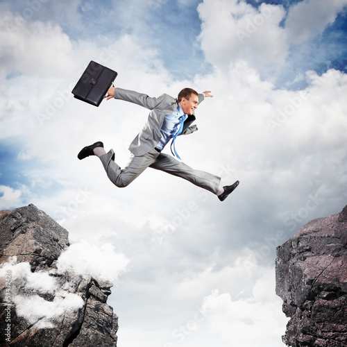 Photo: Businessman jumping over gap Businessman jumping over gap