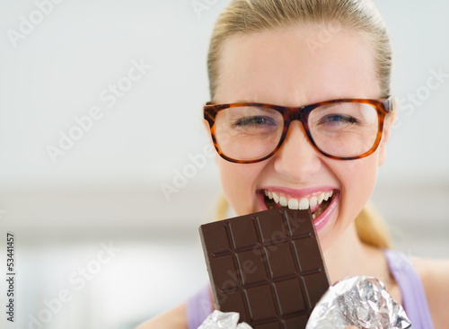 Photo: Happy teenage girl eating chocolate bar Happy teenage girl eating chocolate bar