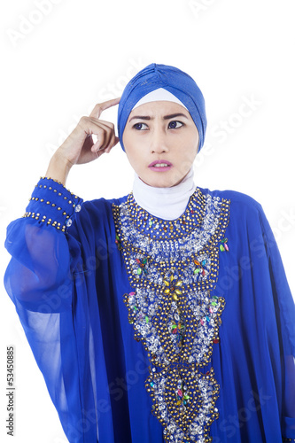 Photo: Confused female muslim in blue dress - isolated Confused female muslim in blue dress - isolated