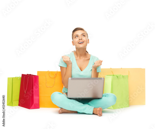 Photo: woman with laptop and shopping bags woman with laptop and shopping bags