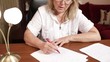 Middle-aged woman writing at the table
