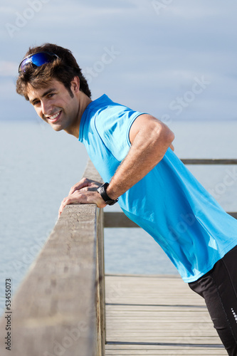 Photo: Young man doing push ups near the sea Young man doing push ups near the sea