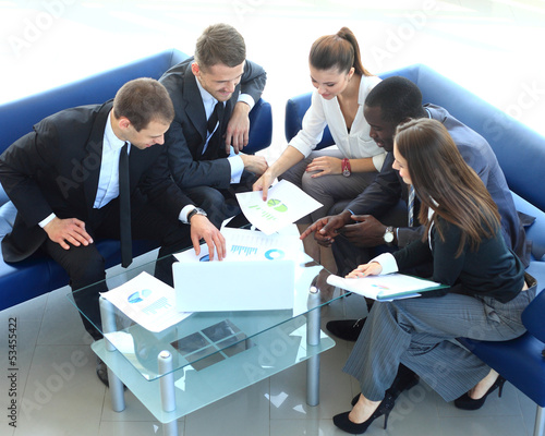 Photo: Top view of working business group sitting at meeting Top view of working business group sitting at meeting